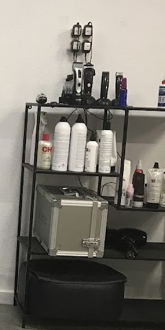 De plank in de salon met tondeuses, f&ouml;hn en kleurproducten.